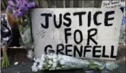  ?? KIRSTY WIGGLESWOR­TH — THE ASSOCIATED PRESS ?? A poster and flowers are left near Grenfell Tower in London, Saturday. Police Commander Stuart Cundy said Saturday it will take weeks or longer to recover and identify all the dead in the public housing block that was devastated by a fire early...