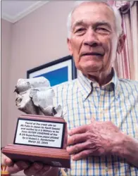  ??  ?? Korean War veteran Clem Kordsmeier shows a piece of the plane that his brother Lt. Hubert L. Kordsmeier was flying during World War II when it crashed at Mount Fubo in Japan. Hubert Kordsmeier and the rest of the crew were killed.