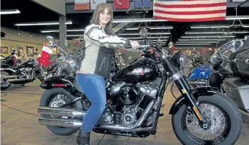  ?? IVAN MORENO/THE ASSOCIATED PRESS ?? Terri Meehan poses on a 2018 Harley Softail Slim in Milwaukee. Meehan took a riding course at the dealership as part of Harley-Davidson’s Riding Academy, an initiative the company hopes will help bring new customers.
