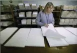  ??  ?? Collator Elizabeth Bouvier assembles pages of a Braille book at the National Braille Press.