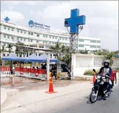  ?? HENG CHIVOAN ?? A food delivery man rides past the Nokor Tep Women’s Hospital, now known as Luong Mer Hosptial, in Prey Sar commune of Phnom Penh’s Dangkor district on March 28, 2021.