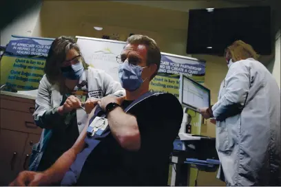  ?? JANE TYSKA — BAY AREA NEWS GROUP ?? Registered nurse Matthew Brenner receives a COVID-19 vaccine at the Contra Costa Regional Medical Center in Martinez on Dec. 15, 2020.