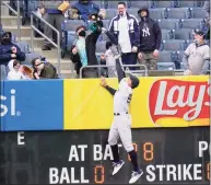  ?? Frank Franklin II / Associated Press ?? A fan catches a ball hit by the Rays’ Francisco Mejia for a home run as Yankees right fielder Aaron Judge (99) leaps at the wall Saturday.