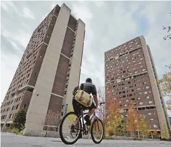  ?? STAFF FILE PHOTO BY CHRISTOPHE­R EVANS ?? BANKING IT: A bicyclist rides past high-rise residence halls at the University of Massachuse­tts Amherst campus. UMass employees are the top earners in the state.