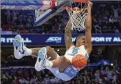  ?? SUSAN WALSH/AP ?? North Carolina’s Armando Bacot hangs from the rim after scoring against Pittsburgh in the ACC semifinal March 15 in Washington. NCAA offensive efficiency is at its highest point in almost three decades