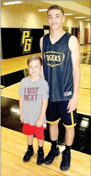  ?? MARK HUMPHREY ENTERPRISE-LEADER ?? Luke Parrish, 8, attends Prairie Grove’s annual peewee basketball camp, and likes to work out with Tiger varsity star D.J. Pearson. Pearson is aware he has an influence on the younger kids and strives to be a positive role model.