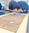  ??  ?? Oxford University’s Dr Alexy Karenowska sniffs a copy of Magna Carta