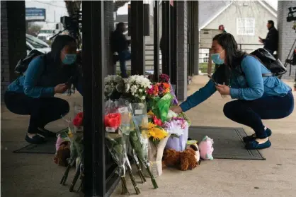  ??  ?? Lijing Zhao, owner of Jo Jos Massage, places a bouquet of flowers outside the spa where four people were shot and killed in Acworth, Georgia, on 17 March. Photograph: Elijah Nouvelage/Getty Images