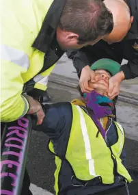  ?? Paul Chinn / The Chronicle ?? San Mateo County sheriff's deputies take a man into custody after protesters chained themselves together across Caltrain tracks at 16th and Mississipp­i streets in S.F.