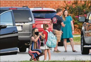  ?? PHOTOS BY HYOSUB SHIN / HYOSUB.SHIN@AJC.COM ?? A Jefferson Elementary student is prepped for Friday’s first day back at school.