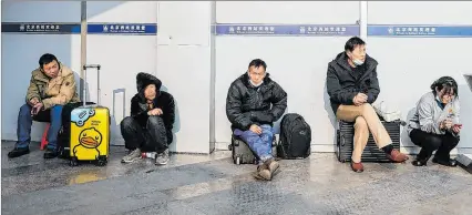  ?? ?? Pekín. Viajeros chinos esperan la hora de salida en la estación de trenes, en un día con el servicio colapsado.