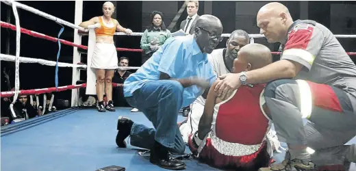  ?? /PUMEZA ZINAKILE ?? Solly Skosana, front left, trainer Stanley Ndlovu and a paramedic attend to dropped boxer Phindile Mwelase.