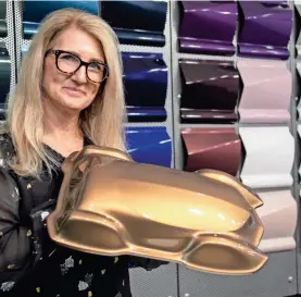  ?? MANDI WRIGHT/DETROIT FREE PRESS ?? Axalta color marketing manager Nancy Lockhart holds a sample of the color Sahara, which the coating company says will be the most popular vehicle color of 2019.