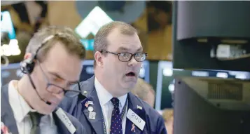  ?? — Reuters ?? Traders work on the floor of the New York Stock Exchange.