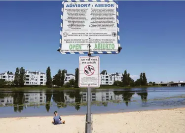  ?? Photos by Lea Suzuki / The Chronicle ?? Lakeshore Park beach displays an advisory stating that water levels are tested weekly for bacteria.