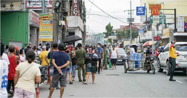  ??  ?? QUEUES have become part of the new normal, like this scene in a market in Cabuyao, Laguna, as establishm­ents could not allow full capacity due to health protocols and restrictio­ns.