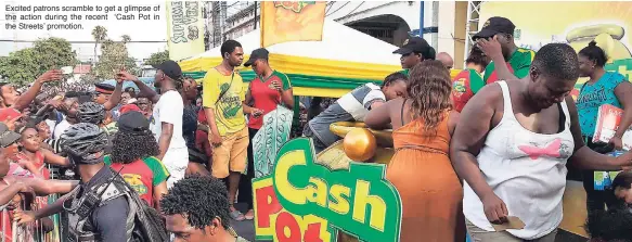  ??  ?? Excited patrons scramble to get a glimpse of the action during the recent ‘Cash Pot in the Streets’ promotion.