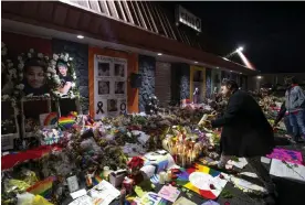  ?? Photograph: Parker Seibold/AP ?? Kebrina Chirdon lights candles at a memorial outside of Club Q on 25 Friday in Colorado Springs, Colorado.