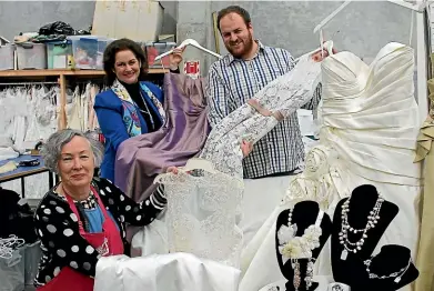  ??  ?? Te Omanga Hospice shop volunteer Colleen Marcanik, left, Te Omanga Hospice retail support manager Margaret Williams and donor Brady Dyer display some of the dresses from the Dyer’s donation.