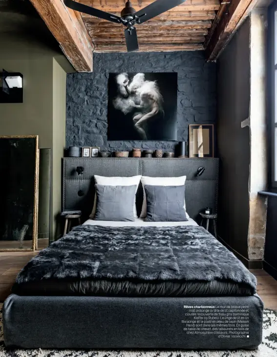  ??  ?? Rêves charbonneu­x Le mur de brique peint mat prolonge la tête de lit capitonnée et cloutée recouverte de tissu gris Dominique Kieffer by Rubelli. Le linge de lit en lin Baralinge et le plaid en peau de lapin (Maison Hand) sont dans les mêmes tons. En guise de table de chevet, des tabourets en bois de chez Atmosphère d’Ailleurs. Photograph­ie d’Olivier Valsecchi.