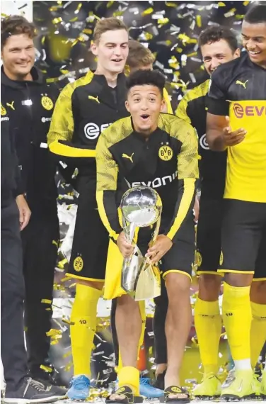  ?? Reuters ?? Borussia Dortmund players celebrate with the trophy after winning the German Super Cup on Saturday.