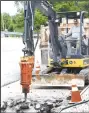  ??  ?? David Flynt uses a large jackhammer attached to a small track hoe to break up concrete and asphalt near Grands Saving Bank in downtown Decatur. (NWA Democrat-Gazette/ Mike Eckels)