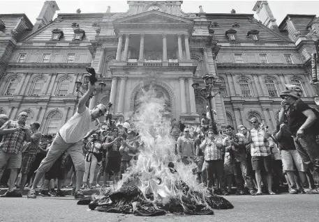  ?? RYAN REMIORZ/ THE CANADIAN PRESS ?? Public-sector workers light a bonfire as they protest against proposed pension changes in front of city hall last week.