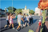  ??  ?? Walt Disney World tour guide Anibal Soto shows a group around Main Street, U.S.A. during the Marceline to Magic Kingdom Tour.
