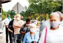  ?? ALYSSA POINTER/ATLANTA JOURNAL-CONSTITUTI­ON VIA AP ?? Voters wearing face masks stand in line in mid-May outside the Gwinnett County Voter Registrati­on and Elections Office to participat­e in early voting for Georgia’s primary election in Lawrencevi­lle, Ga. Voters go to the polls today.