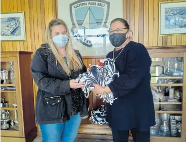  ?? Picture: ZIZONKE MAY ?? TAKING PRECAUTION­S: Victoria Park Grey Primary grade 6 head Jamie Stobbs receives masks for returning pupils from deputy principal Cathy Newman. The school’s management says it will be welcoming grades 6 and 3 on Monday and not grade R