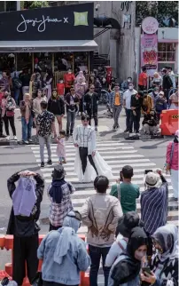 ?? Photo: AFP ?? A crowd look on as Indonesian youths present self-styled fashion creations at a pedestrian crossing-turned-catwalk in Jakarta, Indonesia on July 24, 2022.