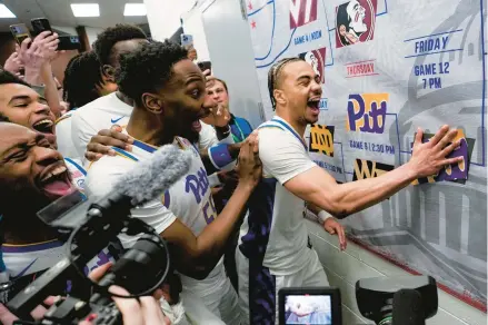  ?? SUSAN WALSH/AP ?? Pittsburgh guard Ishmael Leggett, right, places a decal on the bracket after a win over Wake Forest in the quarterfin­al round of the ACC Tournament on Thursday in Washington.