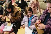  ?? Jarret Liotta / Hearst Connecticu­t Media ?? From left, Maddy, 10, Amelia, 6, and mom Lauren Kessler of Norwalk work on constructi­ng gratitude boxes at Empow-Her — a joint venture by the Norwalk Public Schools and LiveGirl, a New Canaan-based nonprofit aimed at empowering school-age girls. It was held at Brien McMahon High School in Norwalk on Thursday.