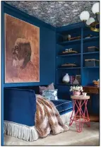  ?? (Courtesy Jewel Marlowe via The Washington Post) ?? Jewel Marlowe painted her home office in Farrow & Ball Stiffkey Blue and covered the ceiling with Spoonflowe­r wallpaper. She accessoriz­ed the space with artwork from Minted and a glamorous fixture by Hudson Valley Lighting.
