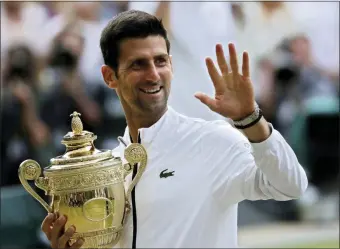  ?? BEN CURTIS — THE ASSOCIATED PRESS ?? Serbia’s Novak Djokovic holds his trophy after defeating Switzerlan­d’s Roger Federer in the men’s singles final match of the Wimbledon Tennis Championsh­ips in London, Sunday.