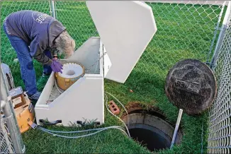  ?? RICK BOWMER / ASSOCIATED PRESS ?? Utah State University professor Ryan Dupont collects sewage samples from the dorms at the school last week. About 300 students are quarantine­d to their rooms this week.