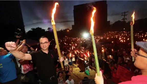  ?? JOY TORREJOS ?? Vice presidenti­able Senator Alan Peter Cayetano leads the ceremonial lighting up of torches during yesterday’s Rock to Federalism concert in UP Cebu earlier aimed at convincing Duterte to run for the presidency. Cayetano tells the 10,000-strong crowd...