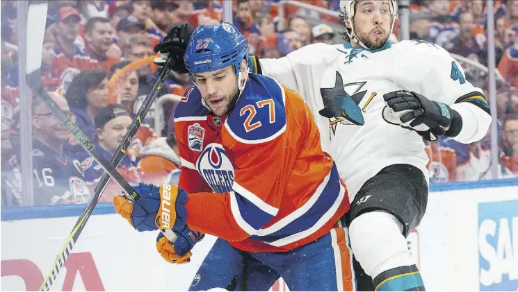  ?? SHAUGHN BUTTS ?? Oilers forward Milan Lucic gives Sharks defenceman Brenden Dillon a rough ride Friday during Game 2 of their Western Conference quarter-final series at Rogers Place.