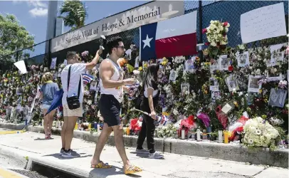  ??  ?? Mourners visit a makeshift memorial near the site of the collapsed tower on Saturday.