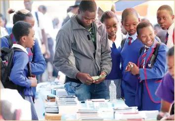  ??  ?? Schoolgirl­s view cellphones on sale in the First Street Mall in Harare yesterday afternoon