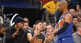  ?? DARRYL WEBB / AP ?? Phoenix Suns’ Chris Paul (right) gets congratula­tions from Kevin Durant (left) and Devin Booker (middle) during the second half of the team’s game against the Los Angeles Clippers on Thursday in Phoenix. The Clippers won 116-107.