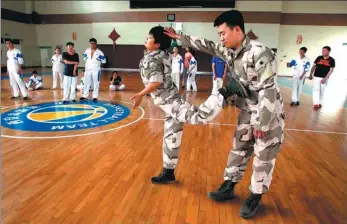  ?? LIANG MENG/FOR CHINA DAILY ?? Young people learn self-defense during a course at a high school in Xi’an, Shaanxi province.