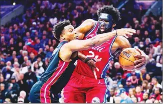  ?? ?? Miami Heat’s Kyle Lowry (left), and Philadelph­ia 76ers’ Joel Embiid battle for the ball during the first half of Game 4 of an NBA basketball second-round playoff series in Philadelph­ia. (AP)