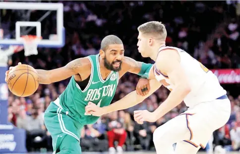  ?? — AFP photo ?? Kyrie Irving (L) of the Boston Celtics moves towards the basket against Doug McDermott of the New York Knicks in the fourth quarter during their game at Madison Square Garden on December 21, 2017 in New York City.