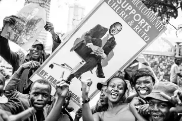  ??  ?? Supporters hold a banner bearing a picture of Kenyatta as they celebrate in Nairobi after the Supreme Court validated his poll victory. — AFP photo