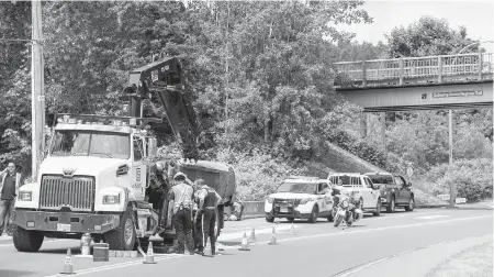  ?? DARREN STONE, TIMES COLONIST ?? Part of Six Mile Road is closed to vehicle traffic after a crane on the back of a truck hit a pedestrian overpass on the Galloping Goose Trail near Atkins Road on Wednesday. The trail overpass was inspected and declared safe.