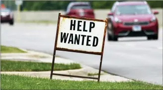 ?? (AP PHOTO/NAM Y. HUH) ?? A help wanted sign is displayed at a gas station in Mount Prospect, Ill., Tuesday, July 27, 2021. The number of Americans applying for unemployme­nt benefits fell last week by 14,000to 385,000, Thursday, Aug. 5, more evidence that the economy and the job market are rebounding briskly from the coronaviru­s recession.