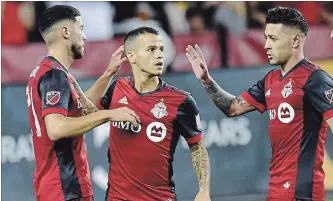  ?? FRANK GUNN THE CANADIAN PRESS ?? Sebastian Giovinco, centre, celebrates his second goal of the game against the Impact. TFC won the game, 3-1.