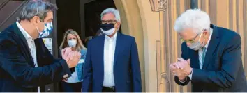  ?? Foto: Stefan Puchner, dpa ?? So sieht ein Handschlag mit Distanz und Masken aus: Markus Söder (links) und Winfried Kretschman­n (rechts) vor dem Ulmer Rathaus. In der Mitte der Gastgeber, Ulms Oberbürger­meister Gunter Czisch.