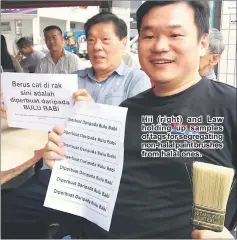  ??  ?? Hii ( right) and Law holding up samples of tags for segregatin­g non-halal paint brushes from halal ones.